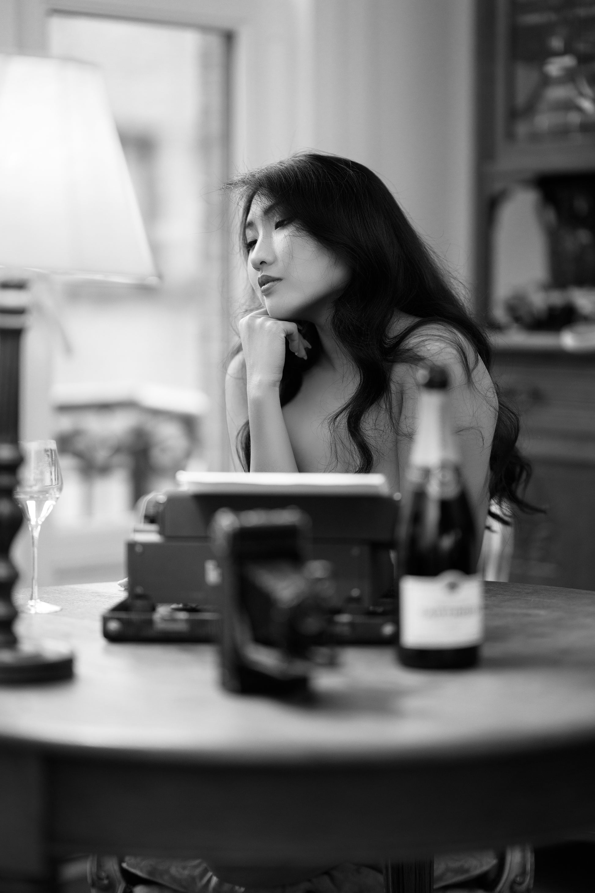 Asian woman with bottle of wine and typewriter